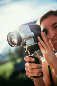 Girl is recording a movie, vintage old movie camera