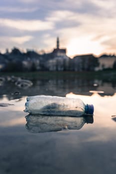 Environmental pollution: plastic bottle on the beach, urban city