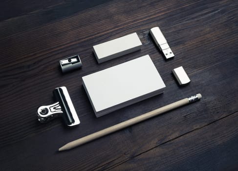 Blank stationery template on wood table background. Blank business card, flash drive, pencil, eraser and sharpener.