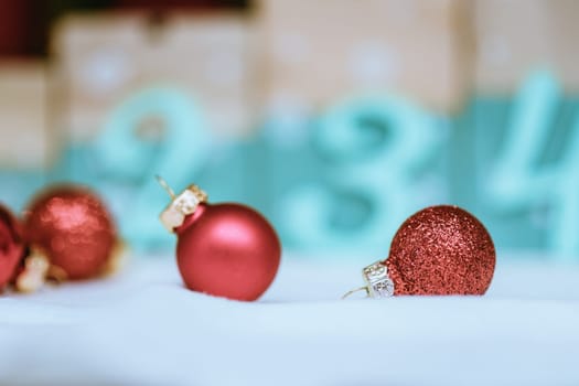 Christmas decoration: Close up of red Christmas baubles, advent calendar in the blurry background