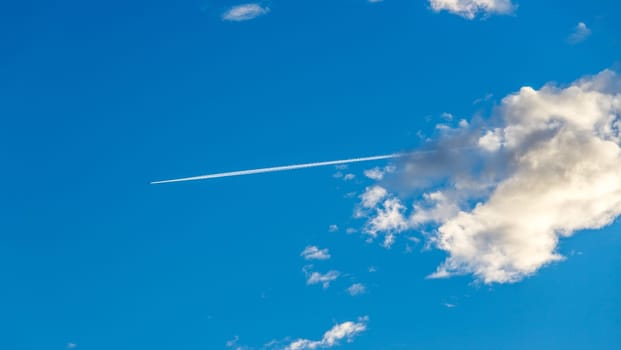 Plane with condensation trail on blue sky