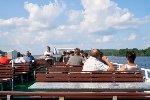Tourists on an excursion boat during a trip on the river Havel with the lake Wannsee near Berlin
