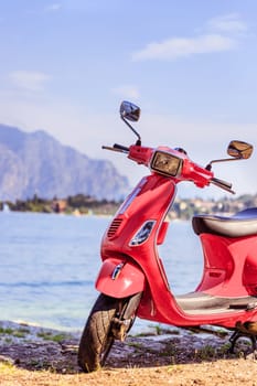 Italian Lifestyle: Red scooter, costal landscape with blue sky. Italy.