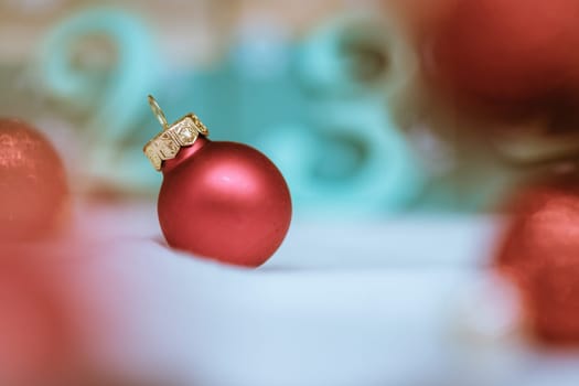 Christmas decoration: Close up of red Christmas baubles, advent calendar in the blurry background