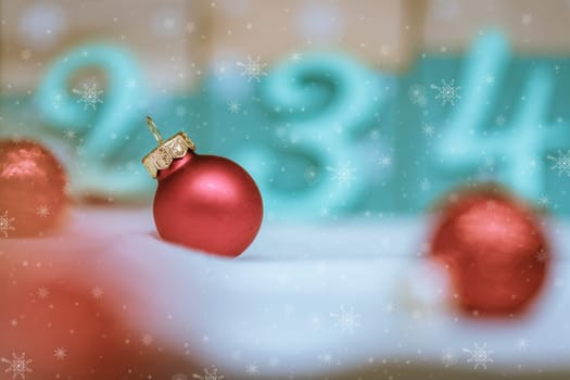 Christmas decoration: Close up of red Christmas baubles, advent calendar in the blurry background