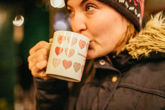 Girl is drinking mulled wine on the Christmas market, fun