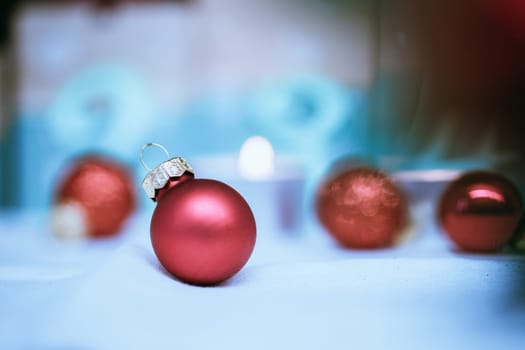 Christmas decoration: Close up of red Christmas baubles, advent calendar in the blurry background