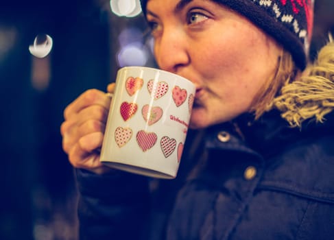 Girl is drinking mulled wine on the Christmas market, fun