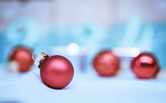Christmas decoration: Close up of red Christmas baubles, advent calendar in the blurry background