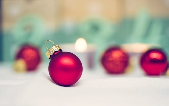 Christmas decoration: Close up of red Christmas baubles, advent calendar in the blurry background