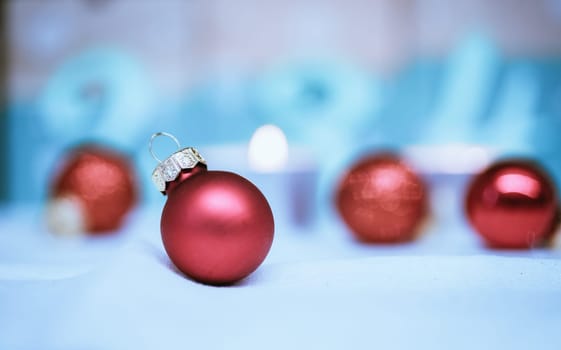 Christmas decoration: Close up of red Christmas baubles, advent calendar in the blurry background