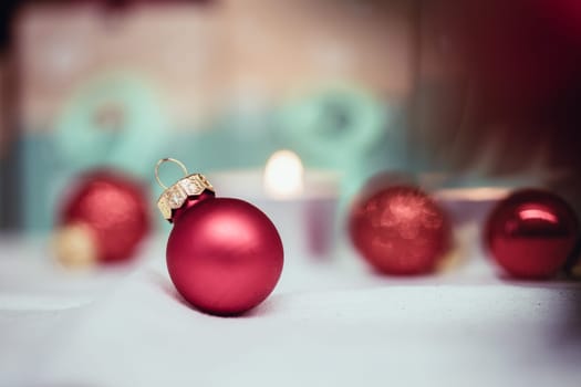 Christmas decoration: Close up of red Christmas baubles, advent calendar in the blurry background