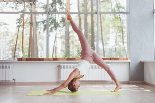 Woman doing single leg downward facing dog yoga pose.