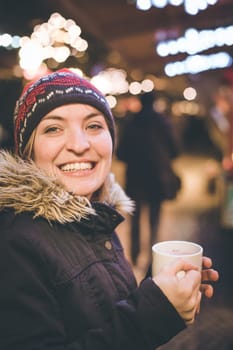 Girl is drinking mulled wine on the Christmas market, fun