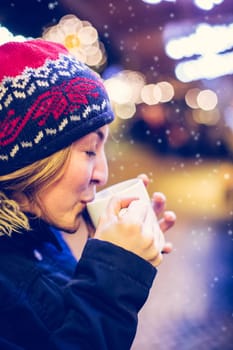 Girl is drinking mulled wine on the Christmas market, fun