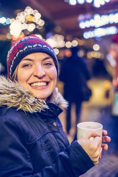 Girl is drinking mulled wine on the Christmas market, fun