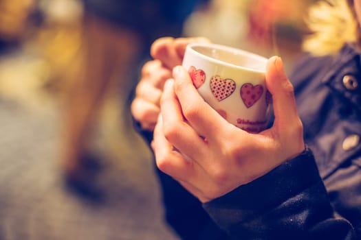 Enjoying Christmas time on the Christmas market. Close up of a cup of mulled wine.