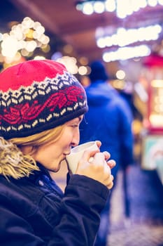 Girl is drinking mulled wine on the Christmas market, fun