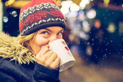 Girl is drinking mulled wine on the Christmas market, fun