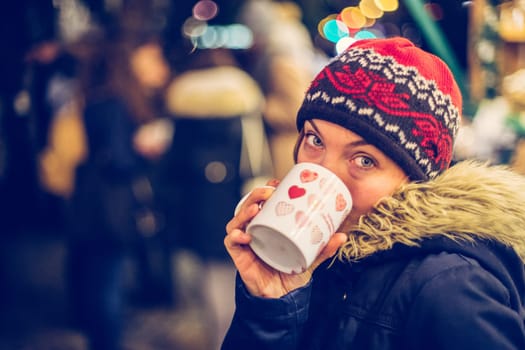 Girl is drinking mulled wine on the Christmas market, fun