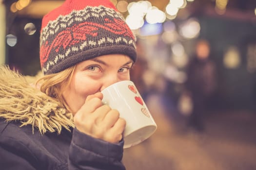 Girl is drinking mulled wine on the Christmas market, fun