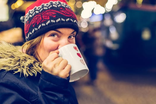 Girl is drinking mulled wine on the Christmas market, fun