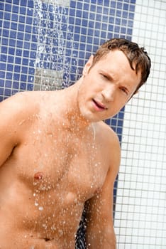 Portrait of handsome blond man under an outdoor shower