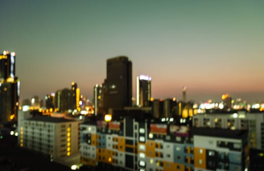 Blurred night city downtown lights with colorful buildings background at twilight time
