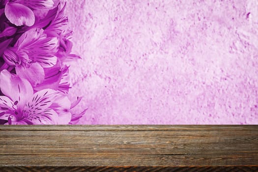 Background flowers on a textured stucco wall and blank wooden planks in the foreground. For product demonstrations, free space, layout, mockup, perspective board, background board.
