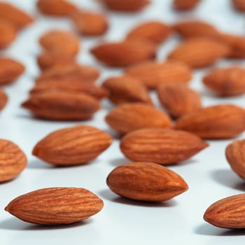 Background of almonds. Fried almonds. Scattered almond grains. Background for advertising, layout, mockup.