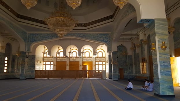 Sharm El Sheikh, Egypt - July 13, 2019. Muslims pray in the temple. The prayer hall in the mosque. Light penetrates through arched windows in El Salam. New mosque with a bright interior.