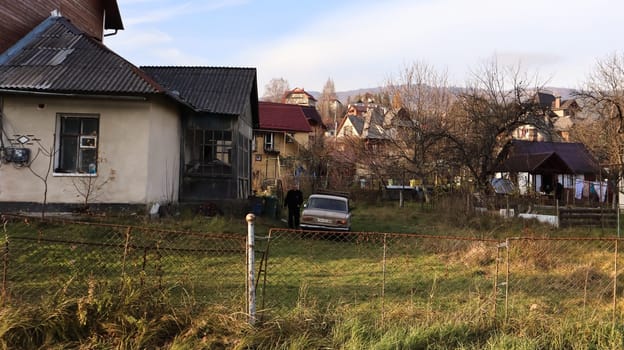 View of the picturesque village houses and cottages against the backdrop of mountains. The city of Yaremche among the Carpathians in the autumn afternoon. Ukraine, Yaremche - November 20, 2019.