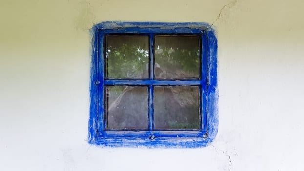 Ukraine, Kiev - June 11, 2020. Old window in a vintage traditional peasant house in Ukraine. Antique wooden window frame. Pirogovo National Museum in the open air in Kiev. Copy space