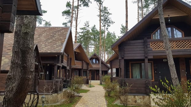 Ukraine, Kiev - April 17, 2020. A country hotel with brown wooden guest houses. Cottage village. The construction of mysterious houses. Infrastructure. To live and relax in the country