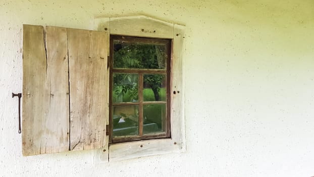 Ukraine, Kiev - June 11, 2020. Old window in a vintage traditional peasant house in Ukraine. Antique wooden window frame. Pirogovo National Museum in the open air in Kiev. Copy space