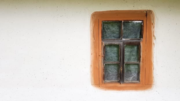 Ukraine, Kiev - June 11, 2020. Old window in a vintage traditional peasant house in Ukraine. Antique wooden window frame. Pirogovo National Museum in the open air in Kiev. Copy space