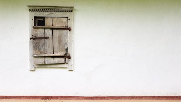 Ukraine, Kiev - June 11, 2020. Old window in a vintage traditional peasant house in Ukraine. Antique wooden window frame. Pirogovo National Museum in the open air in Kiev. Copy space