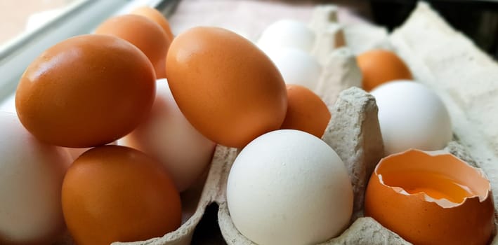 Many white and brown eggs are randomly laid.