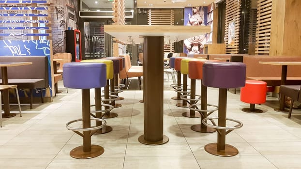 Ukraine, Kiev - August 19, 2019: McDonald's restaurant interior. McDonald's is the world's largest fast food restaurant chain based in the USA. Interior with tall tables and colored bar stools.