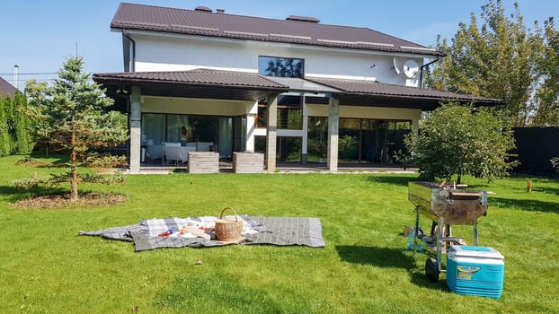 Ukraine, Kiev - September 24, 2019: facade of a new modern Australian-style home. Picnic with a barbecue in the courtyard of a large house on a green lawn. Luxury Villa Resort Interior.