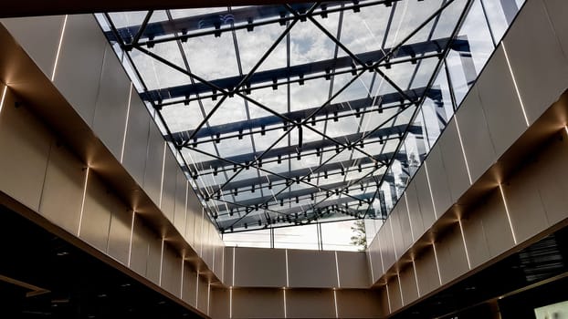 Ukraine, Kiev - September 24, 2019: Structural glazing of the facade. Abstract background with glass ceiling elements in a modern building. view of the blue sky through a glass window, separated by lattice elements