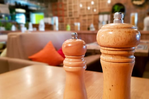 Ukraine, Kiev - September 1, 2019: A table in a cafe or restaurant. Spices salt and pepper on a wooden table, panoramic view.