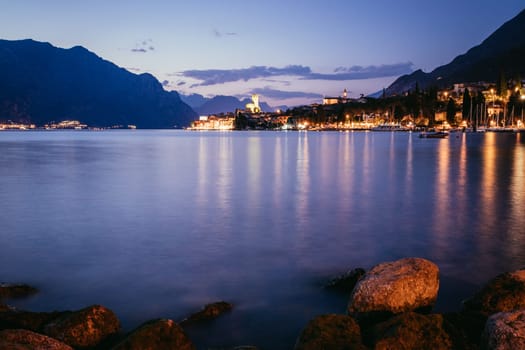 Beautiful night  scenery with cute little village, lago di garda, Italy. Stones in the foreground.