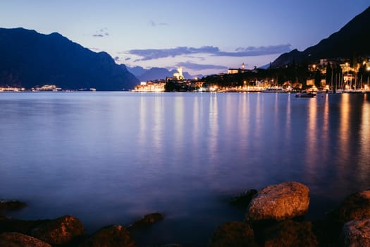Beautiful night  scenery with cute little village, lago di garda, Italy. Stones in the foreground.