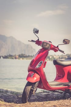 Beautiful red scooter on the beach, landscape and blue sky