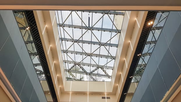 Ukraine, Kiev - September 24, 2019: Structural glazing of the facade. Abstract background with glass ceiling elements in a modern building. view of the blue sky through a glass window, separated by lattice elements