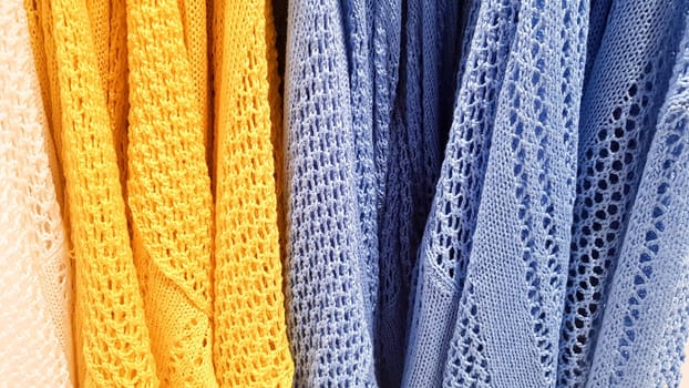 Colors of rainbow. Variety of casual shirts, t-shirts on hangers in a store. Cloth cotton of various bright colors close-up. Textile background.