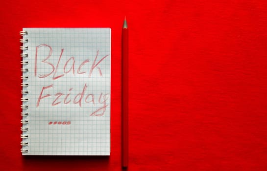 Black friday sale text written on a notepad with a red pencil on a red background. Background, holiday concept. Black Friday - International Day of Shopping, Promotions, Discounts, Sales. Sales season is the fourth Thursday of November. Copy space, place for text, flat lay.