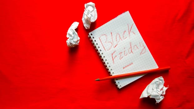 Black friday sale text written on a notepad with a red pencil on a red background. Background, holiday concept. Black Friday - International Day of Shopping, Promotions, Discounts, Sales. Sales season is the fourth Thursday of November. Copy space, place for text, flat lay