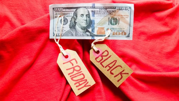 Label paper with the text black friday on a red background with american dollars. Shopping, sale concept. Close-up, copy space.
